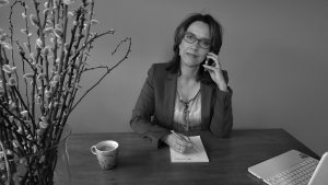 Anette de Jong van wantdatklopt.nl aan haar bureau in telefonisch gesprek